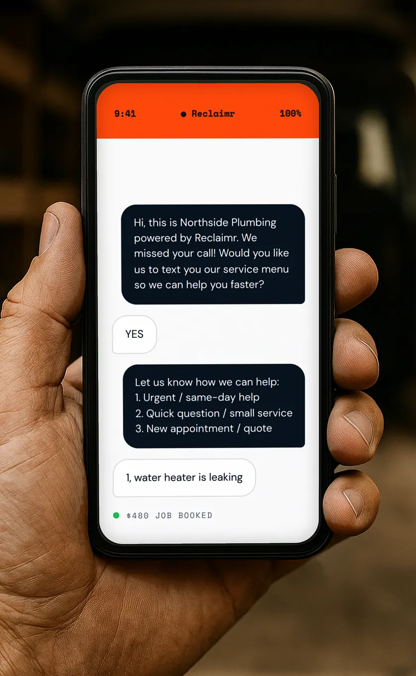 A tradesman’s hand holding a phone in a tool-lined van. On screen, the text Reclaimr sent after a missed call: the business asking permission, the caller replying YES, a three-option menu, and the reply “1, water heater is leaking” — logged as a $480 job booked.